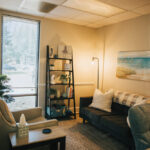 Inside picture of black couch with pillow and seascape, Carolina Counseling located in Greenville, NC
