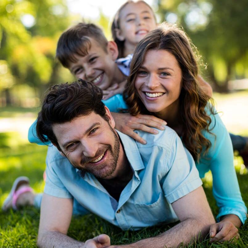 Happy family outside in park setting - Carolina Counseling in NC